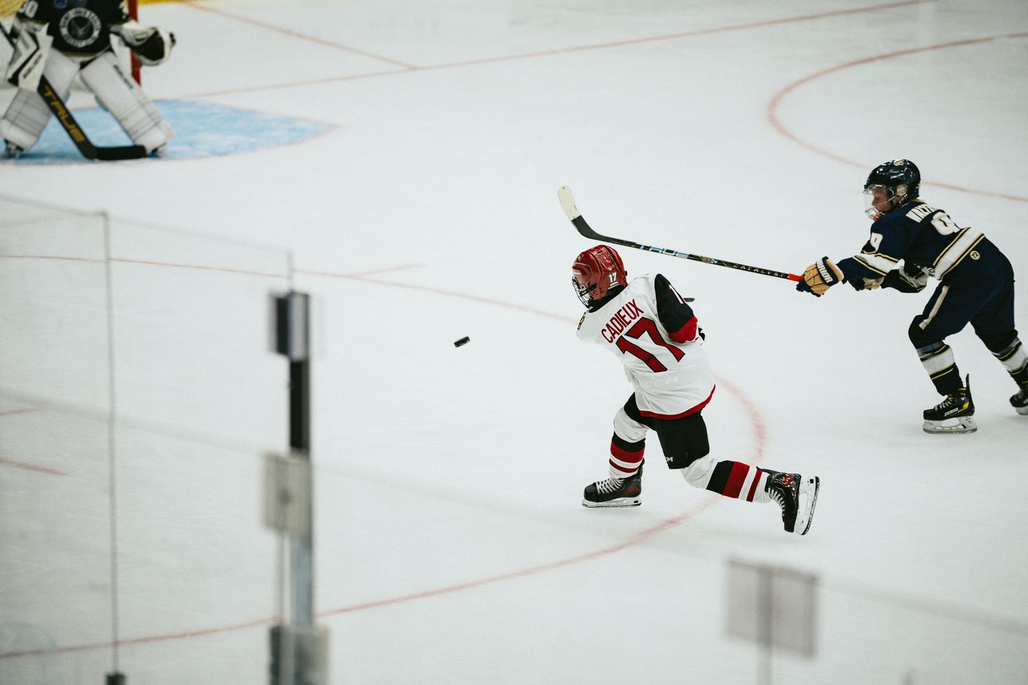 Hockey players in motion on ice during an intense game moment.