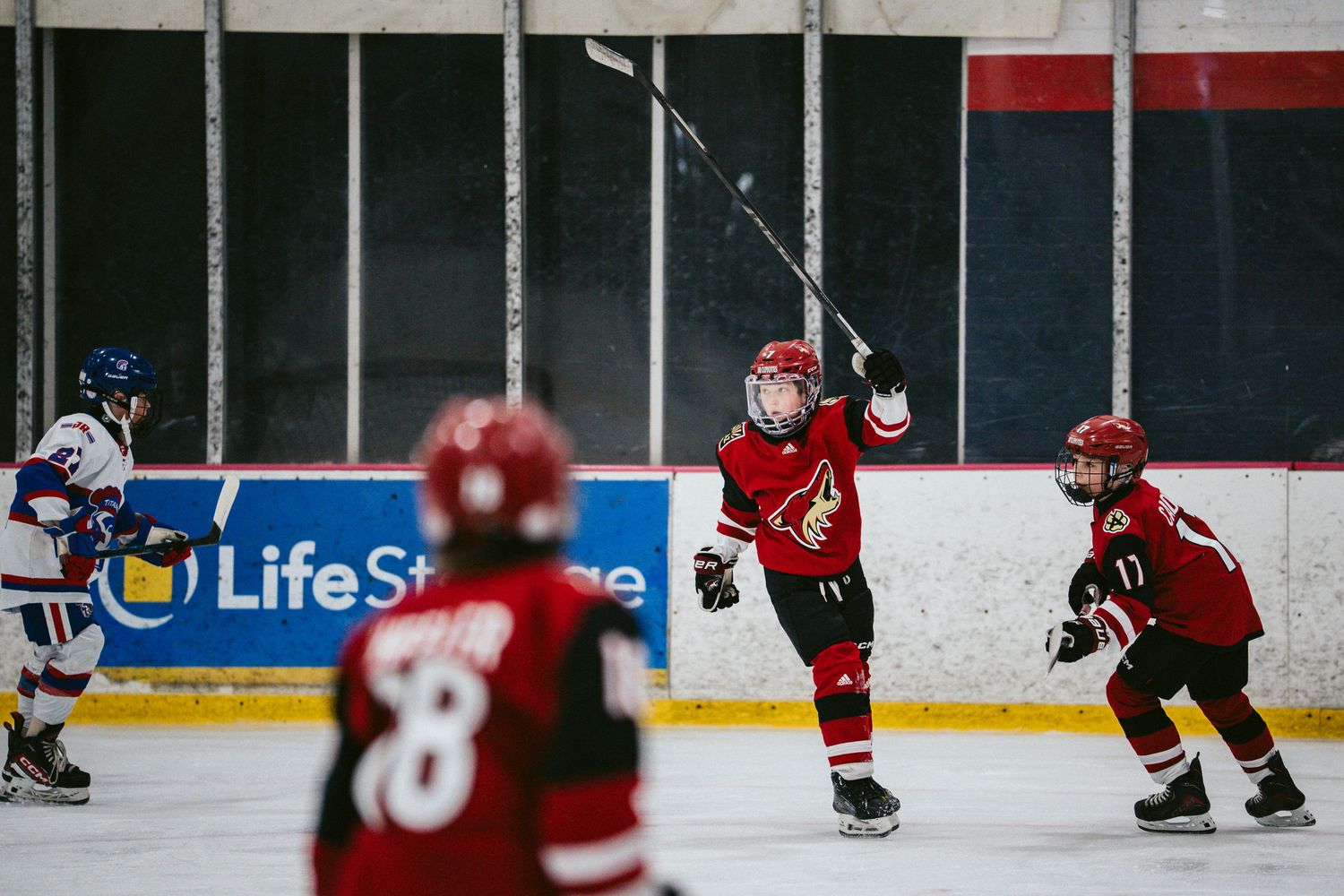 Hockey players in red jerseys spread across the ice during a game.