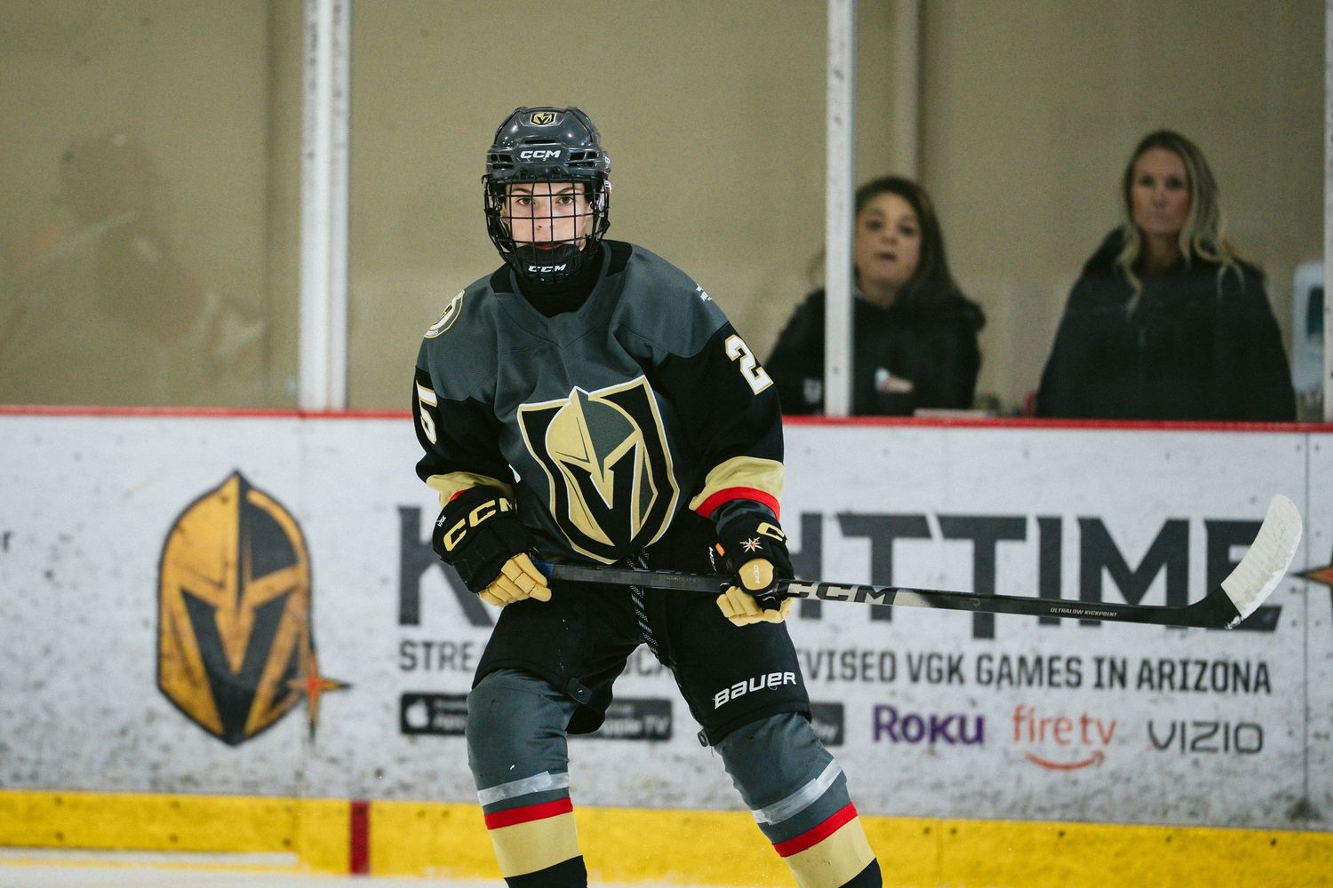 Hockey players in Vegas Golden Knights uniforms practice on the ice.