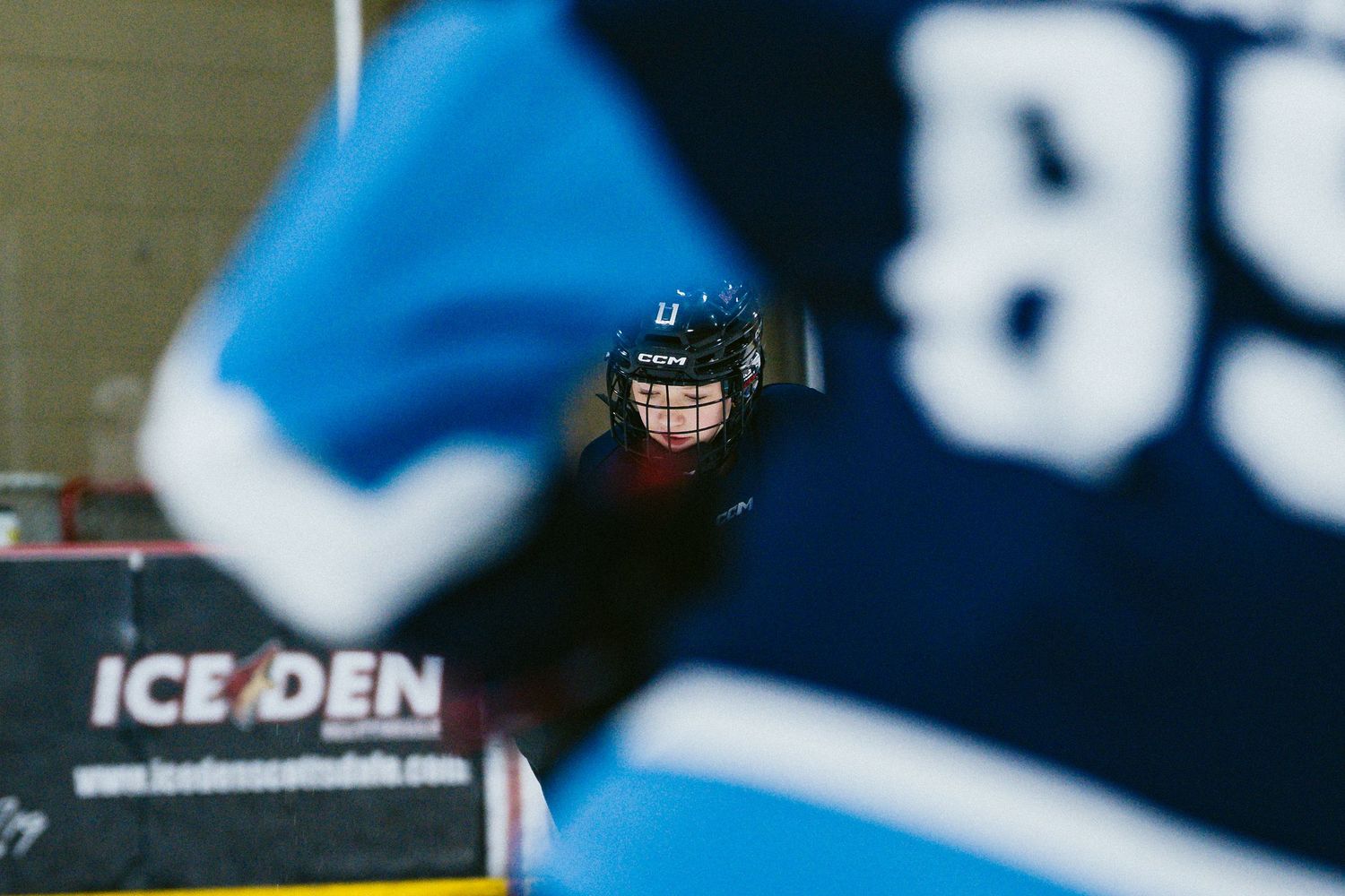Hockey player in blue jersey number 89 on ice rink at Ice Den arena during a game.