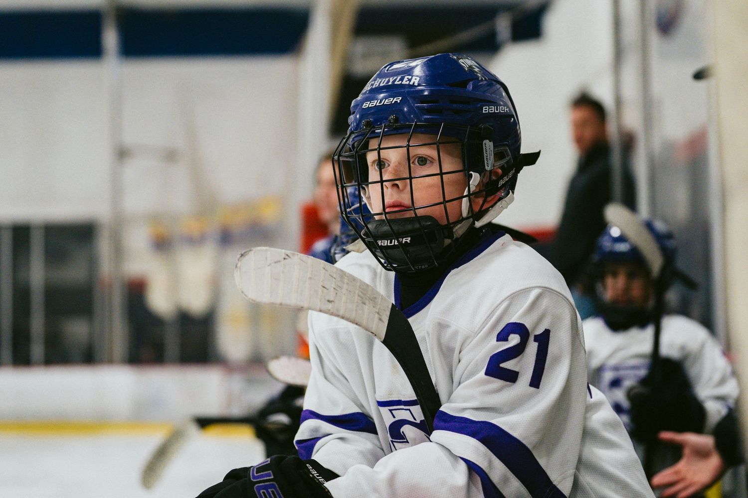 Youth hockey player in blue and white uniform during an ice hockey game.