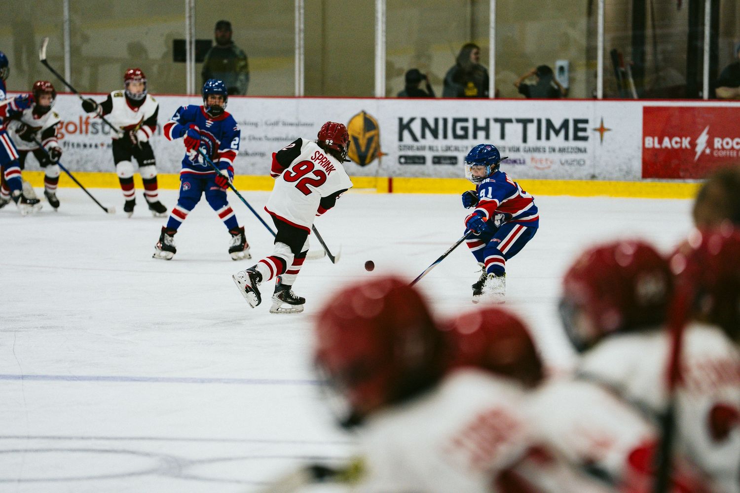 Hockey players from opposing teams face off during an competitive ice hockey match.