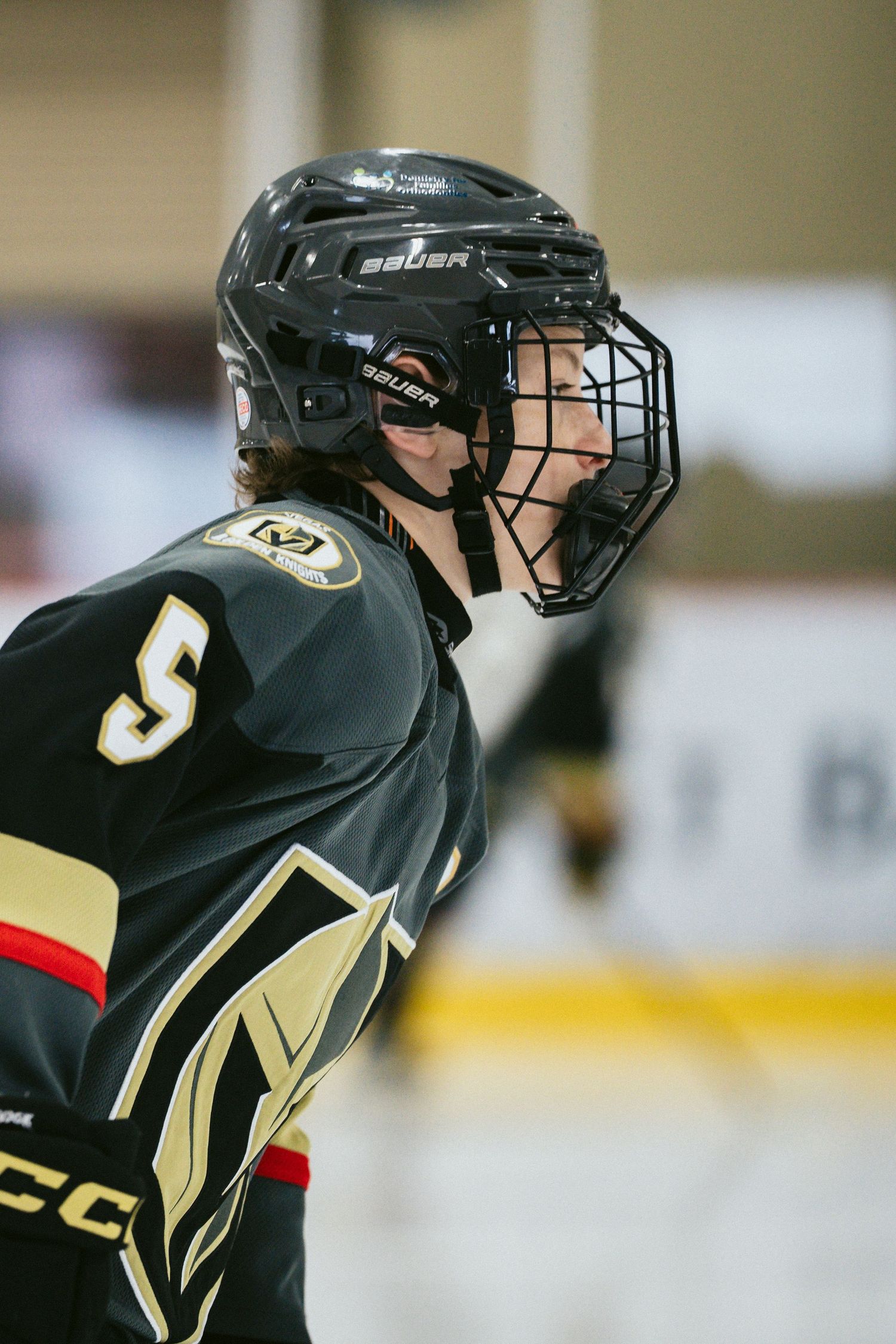 Close-up shots of hockey players wearing black and gold Vegas Golden Knights helmets and equipment.