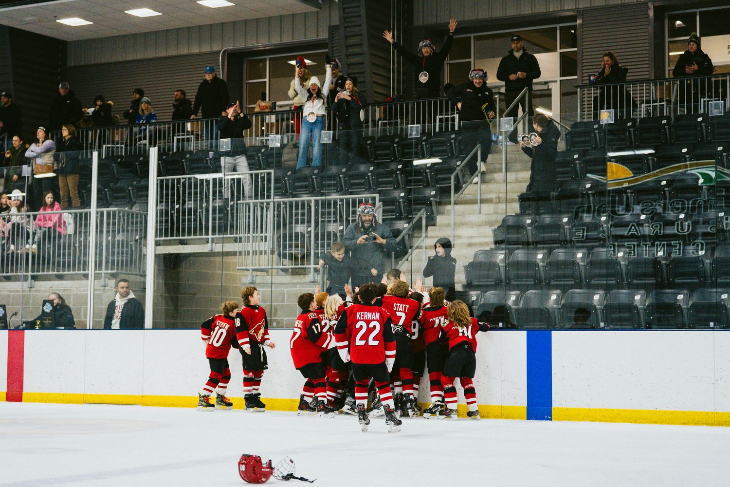 Indoor hockey rink with players in red uniforms during practice session.