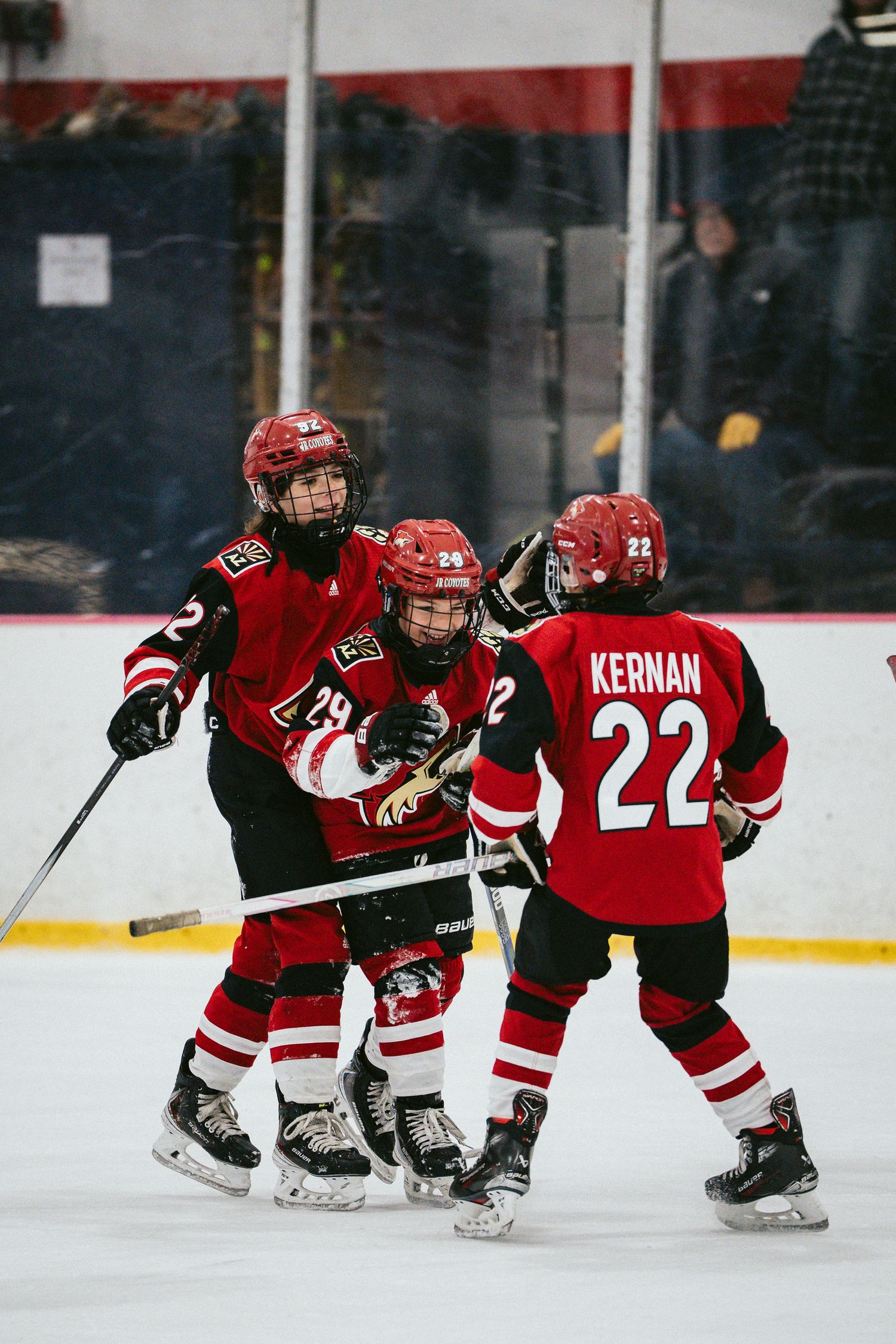 Young hockey players in red uniforms skate in formation during practice.
