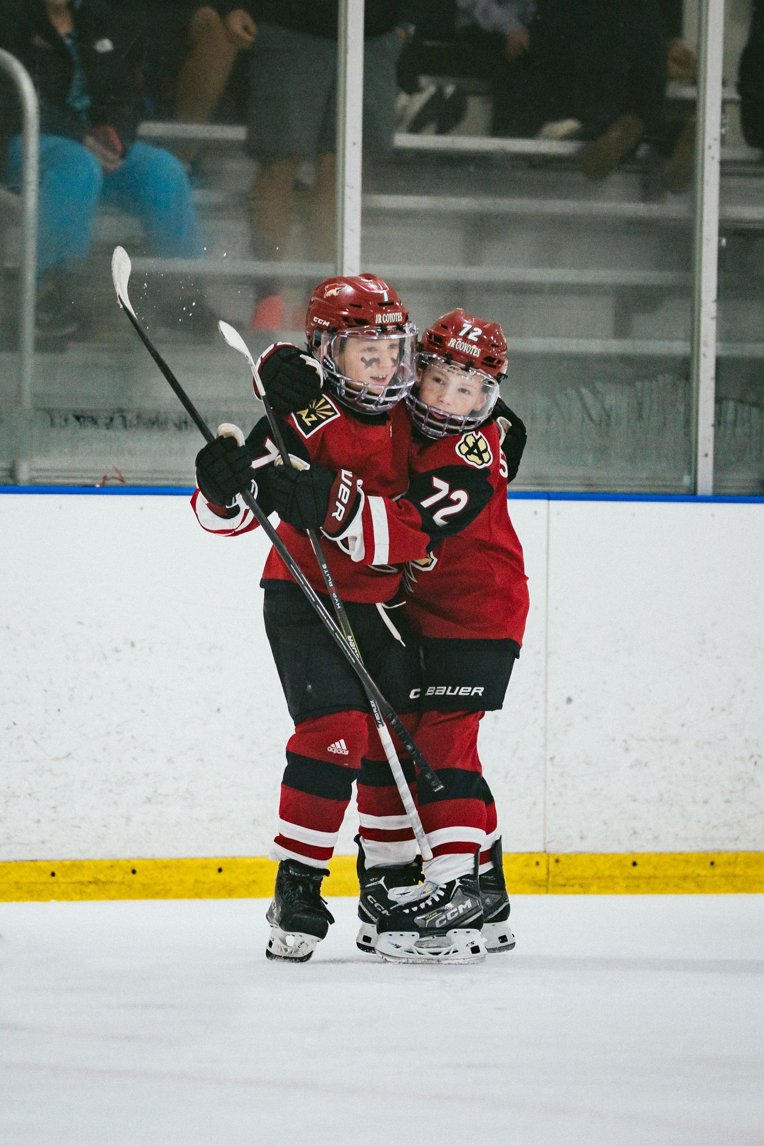 Youth hockey players in red uniforms practicing together on the ice.