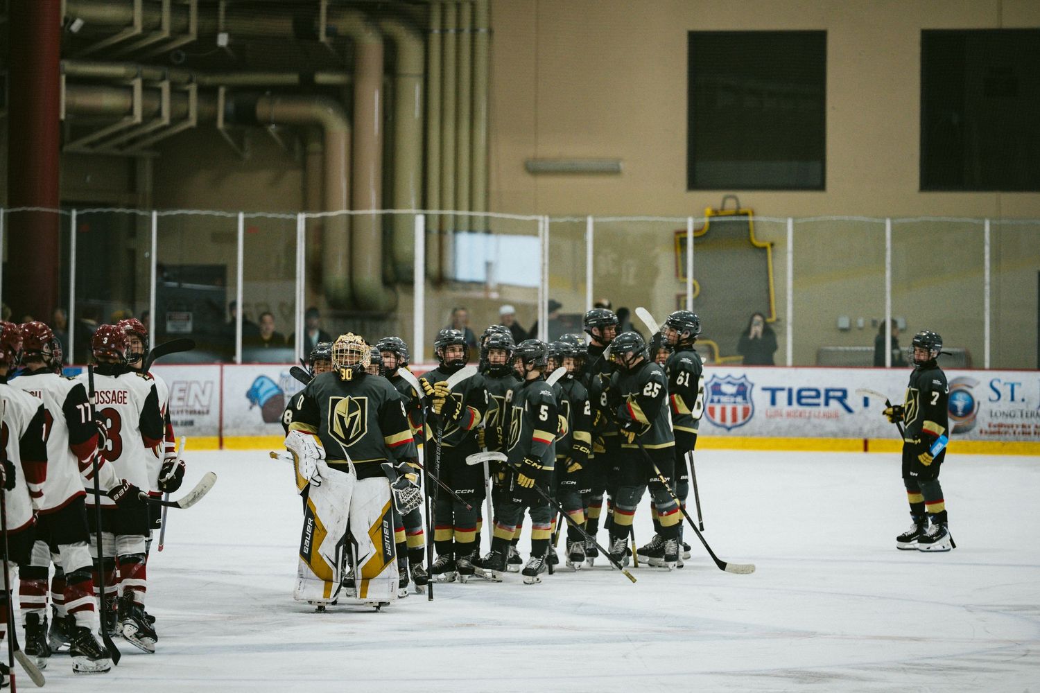 Wide view of a hockey game showing players spread across the ice rink during gameplay.