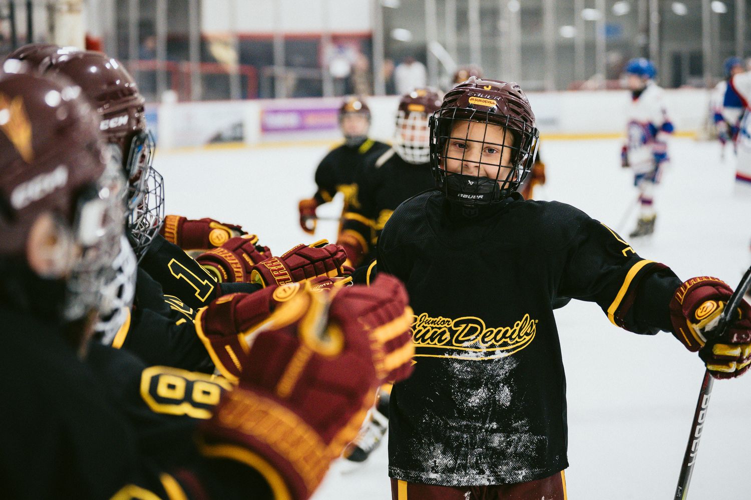 Players in yellow and black jerseys competing during intense hockey match.