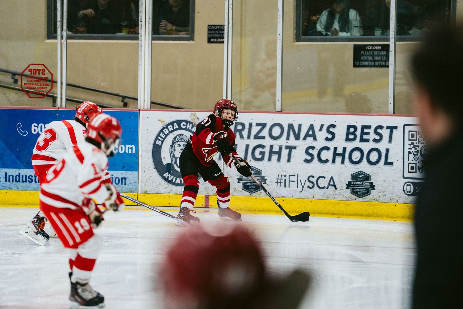 Two hockey players battle for the puck during a game at Arizona's Best Flight School arena.