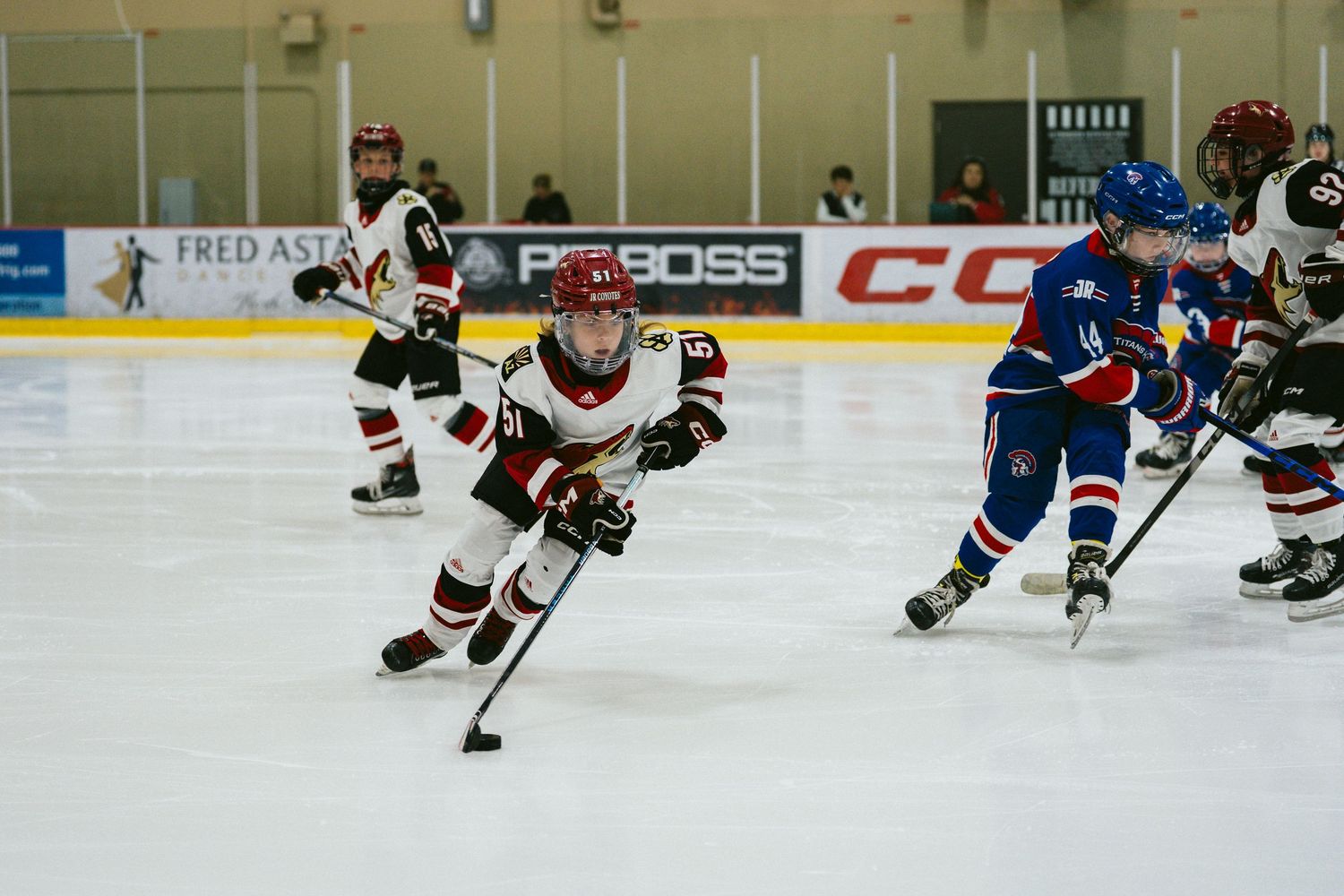 Hockey players from opposing teams compete for the puck during an intense ice hockey match.