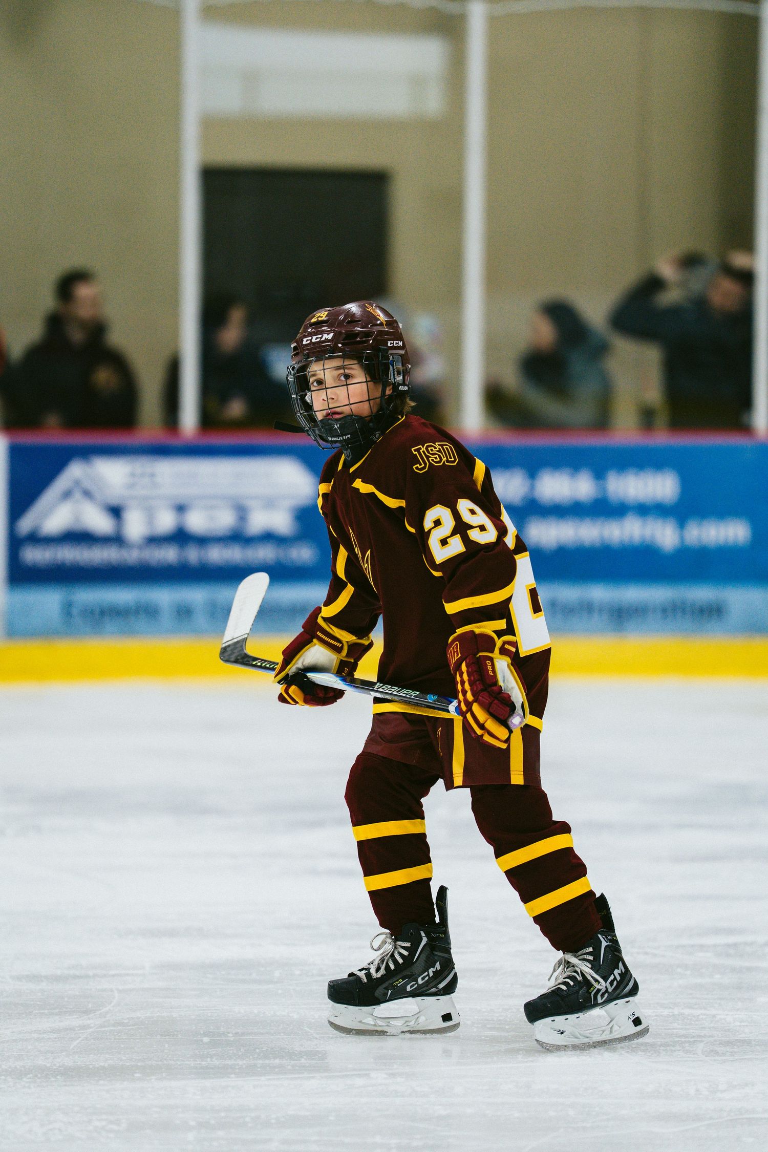 Young hockey players in black and gold uniforms skating during practice.