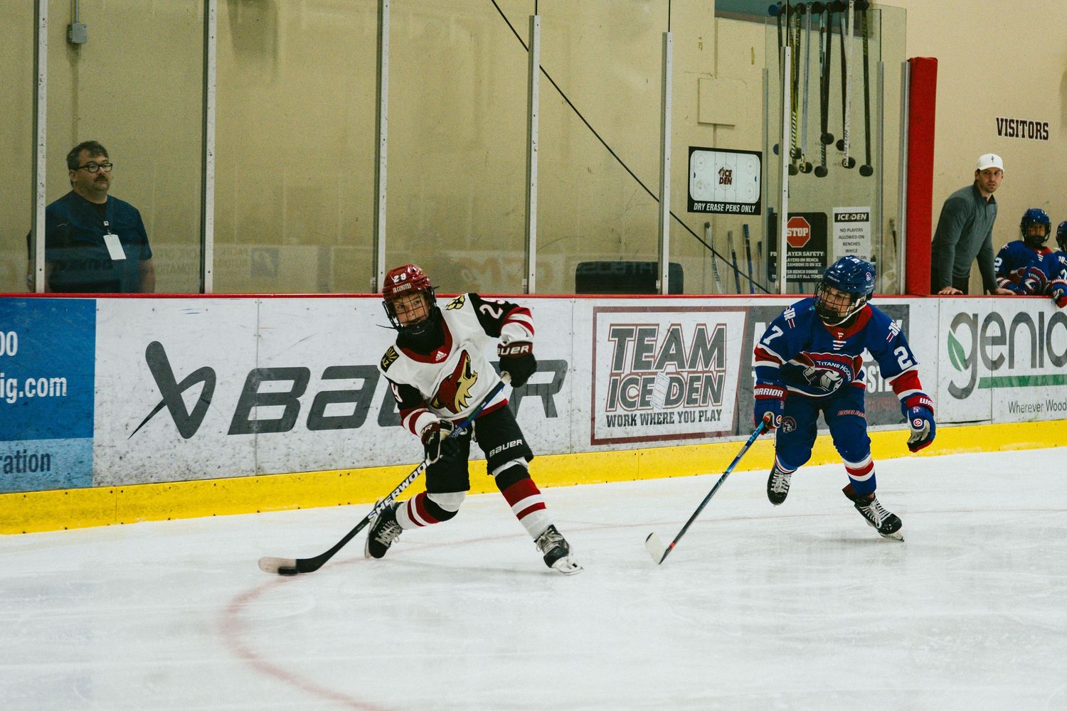 Hockey players from opposing teams compete for the puck during an intense ice hockey match on the rink.