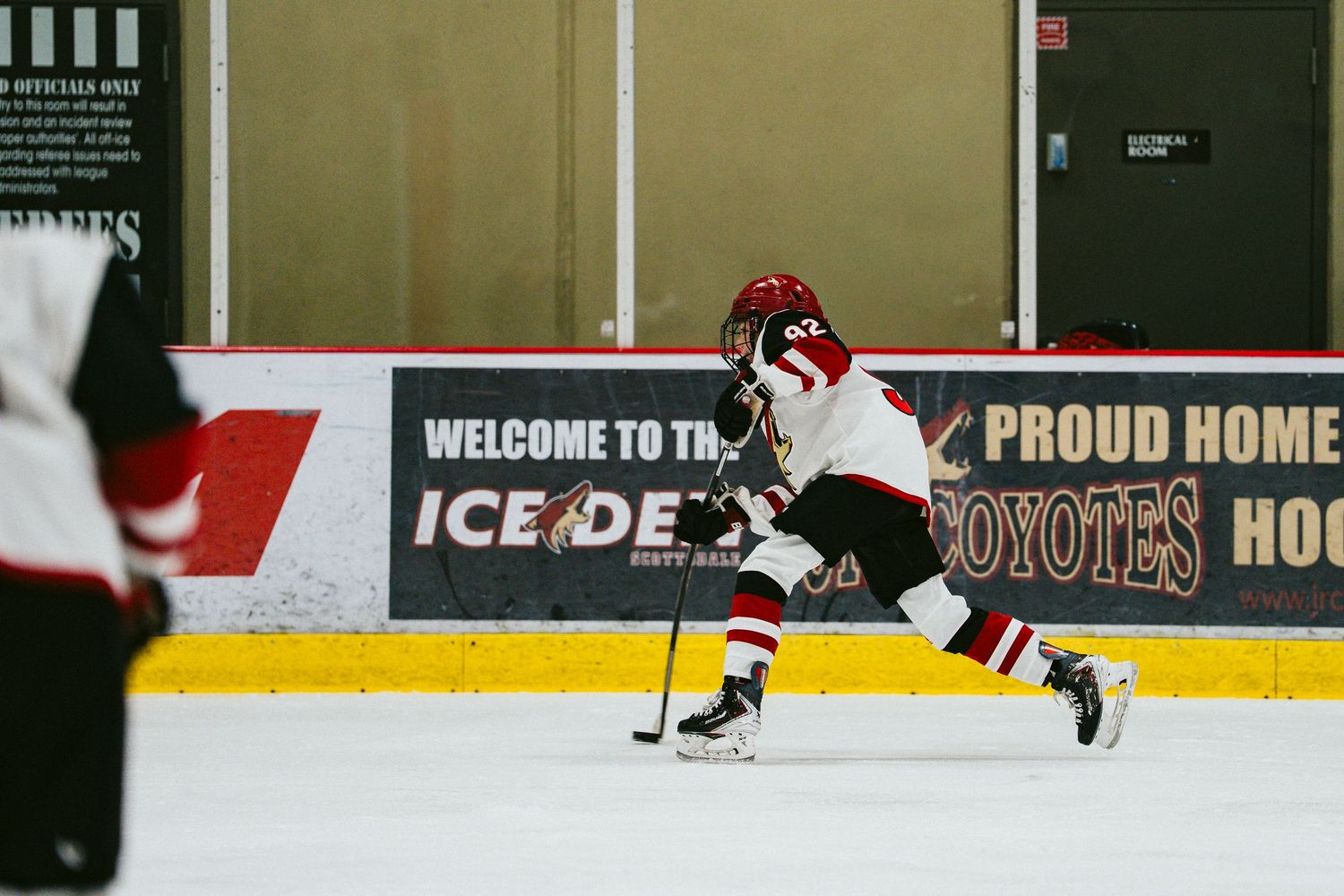 Hockey players in action on the ice with arena signage visible in the background.
