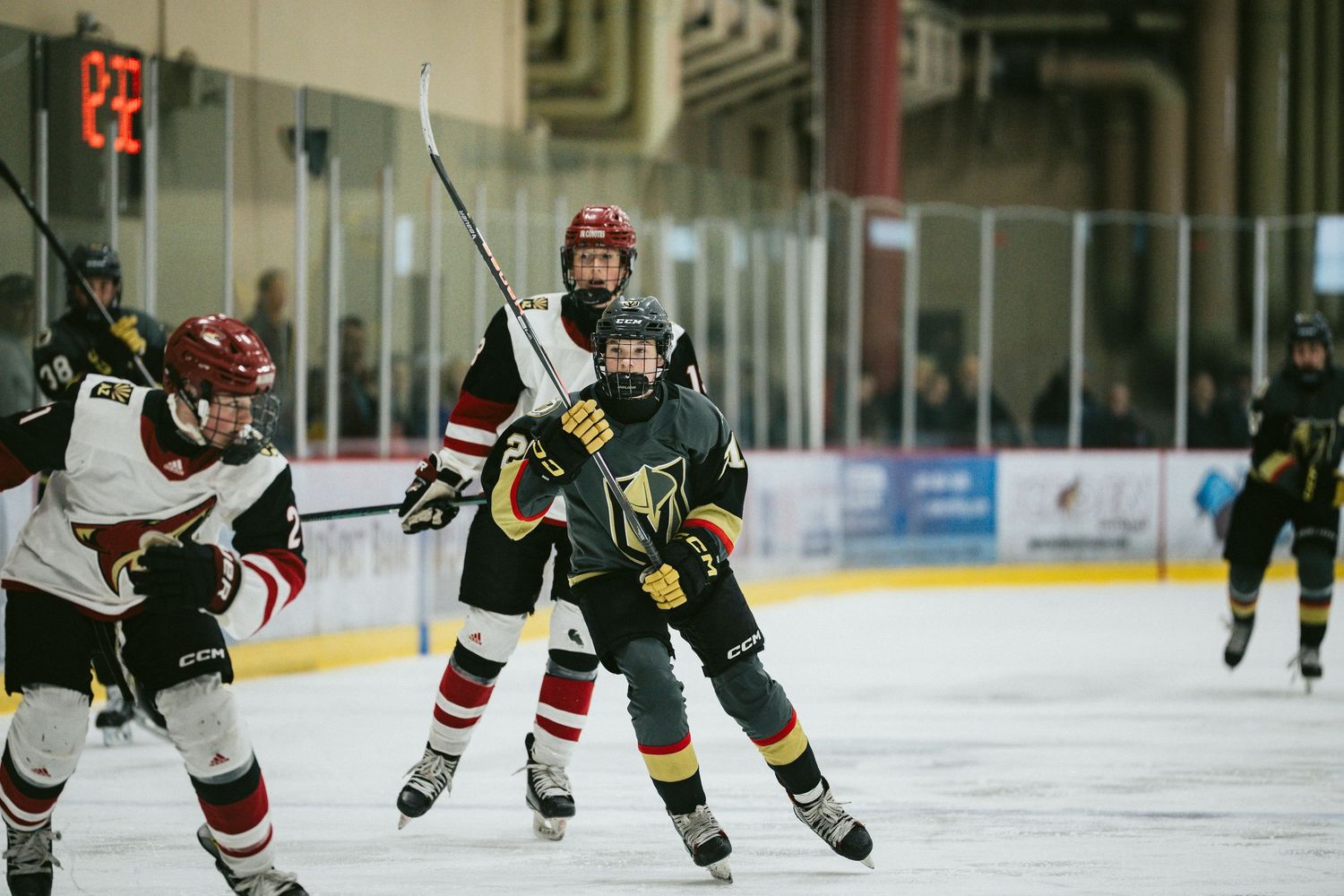 Hockey players from opposing teams compete for the puck during an intense ice hockey match.