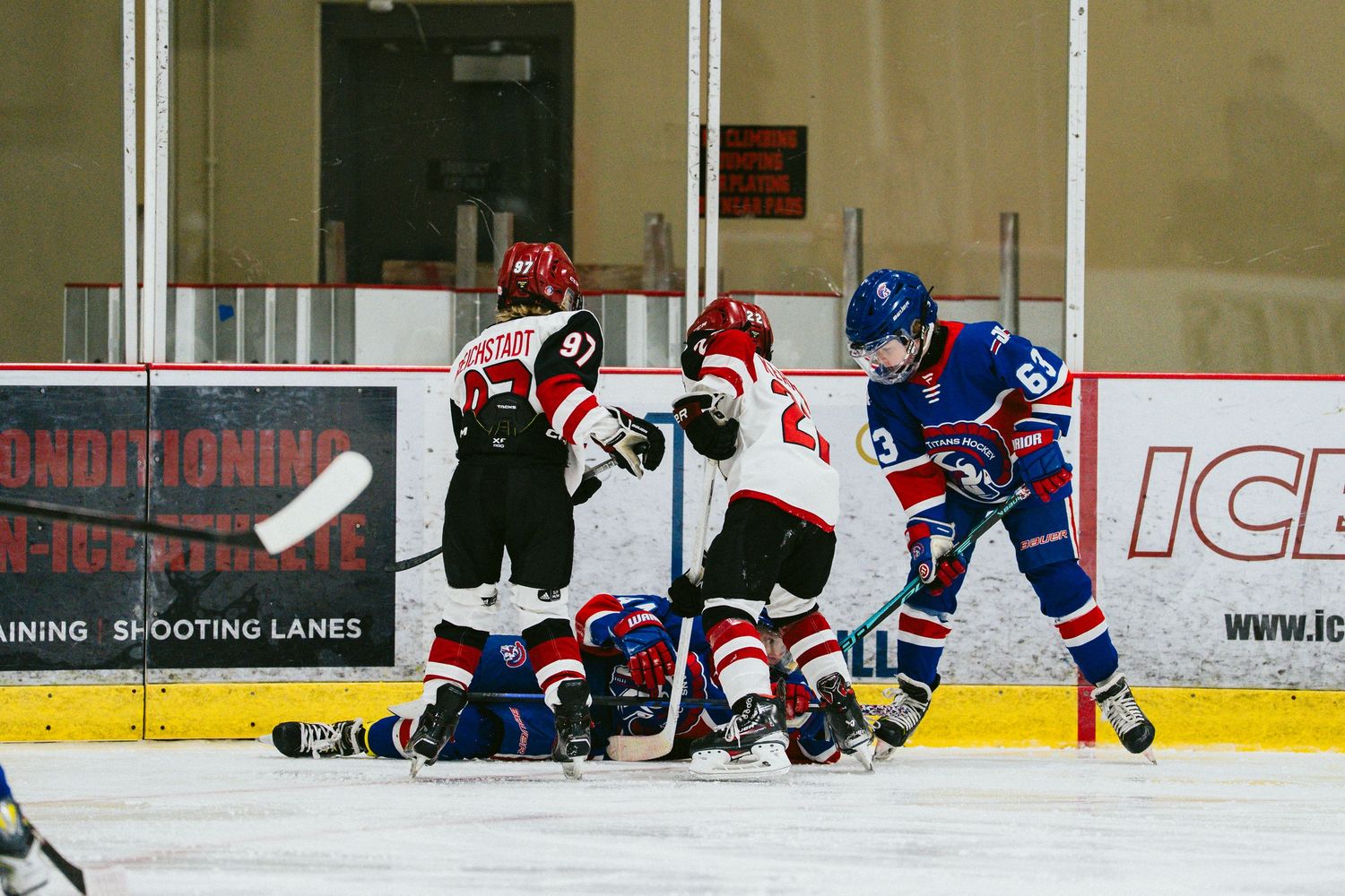 Hockey players from opposing teams battle for the puck during an intense ice hockey game.