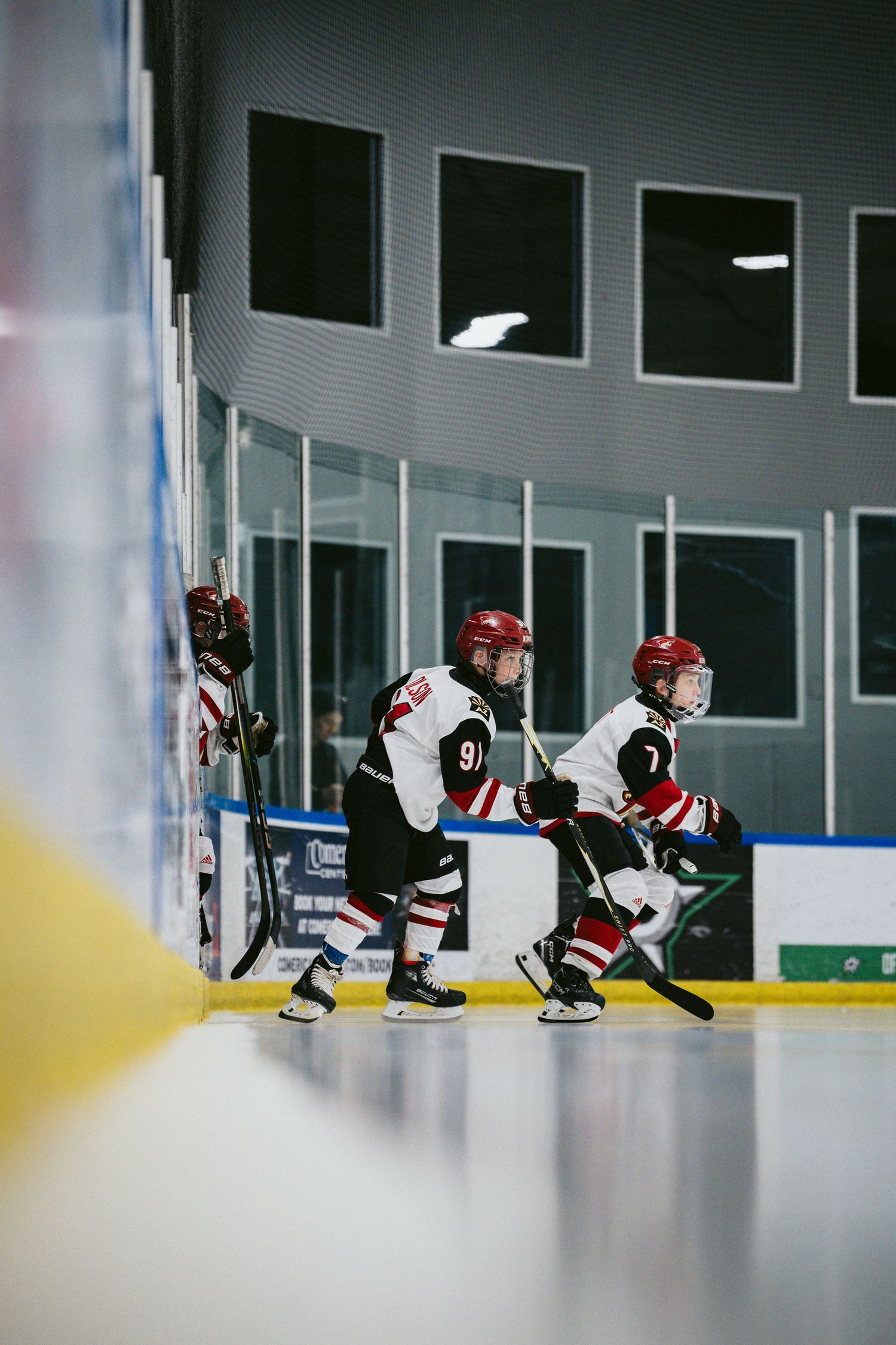 Young hockey players stretch on the ice during practice session.