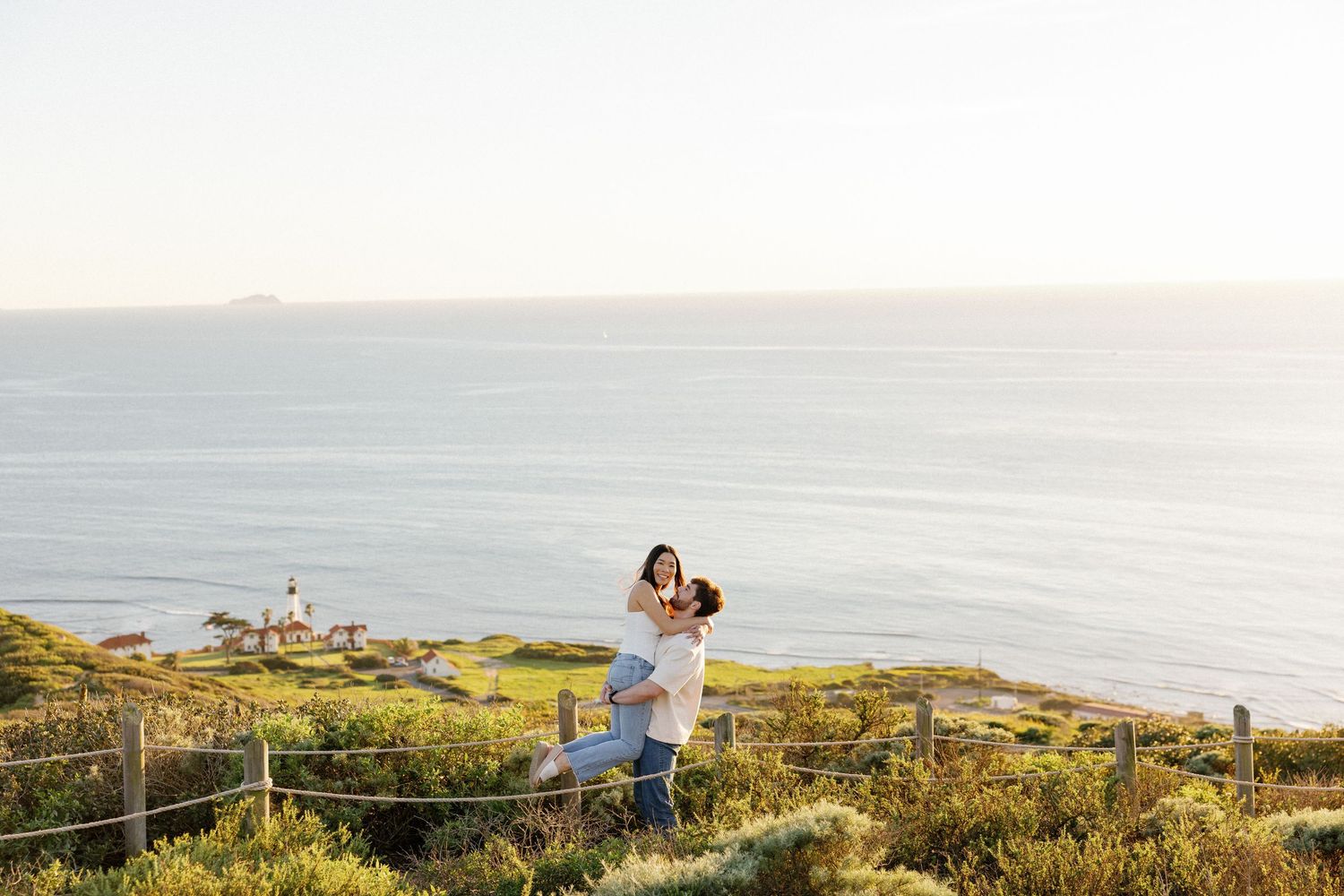 Scenic coastal cliffside overlook with ocean views and people enjoying the sunset at Cape Kiwanda, Oregon.