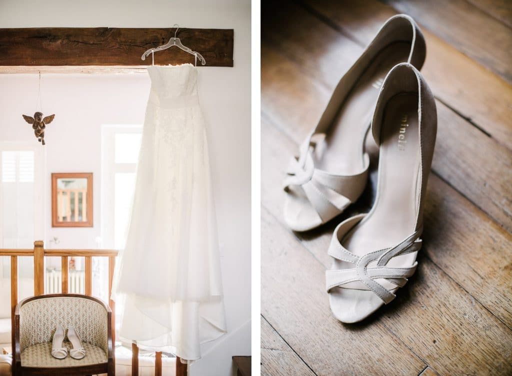 Bridal preparation flat lay featuring white lace wedding dress hanging and white peep-toe heels.