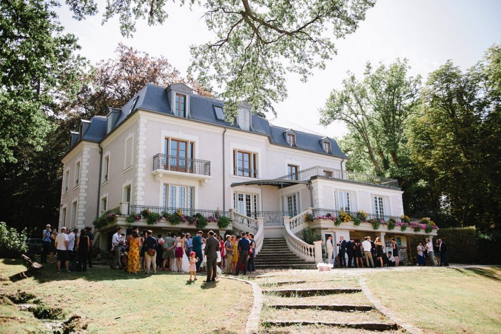 Guests gathered outside an elegant French chateau wedding venue.