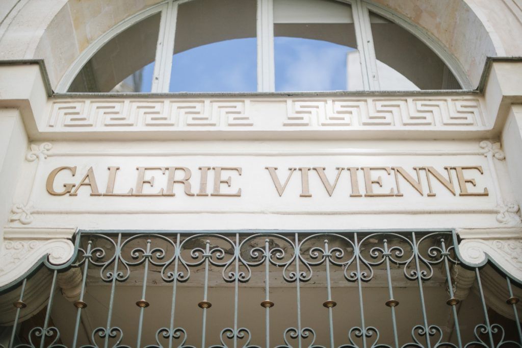 Ornate entrance sign of Galerie Vivienne, a historic covered passage in Paris with elegant gold lettering and iron gates.