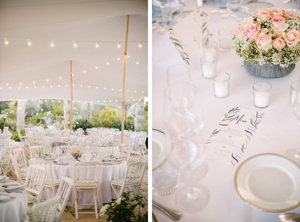 Elegant white wedding reception tent with string lights, round tables, and soft pink floral centerpieces.