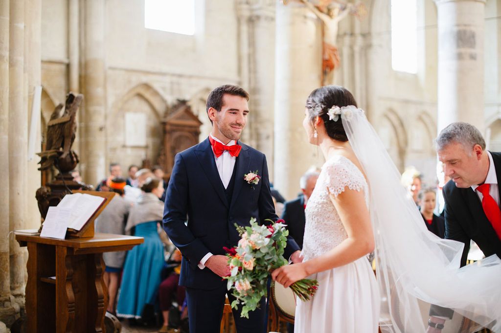 Bride and groom meeting at altar in historic stone church during wedding ceremony.
