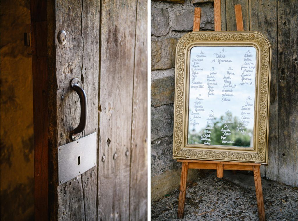 Rustic wooden door with iron handle beside an ornate gold-framed wedding seating chart on easel.