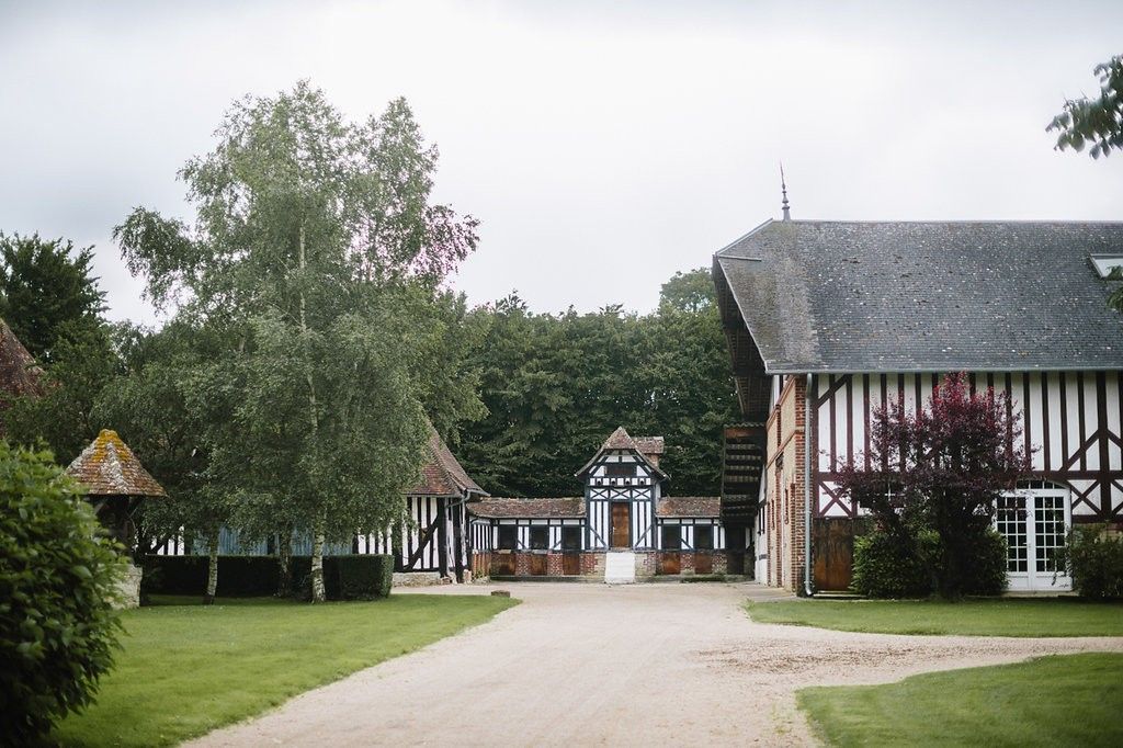 Elegant French Norman-style farmhouse wedding venue with timber framing and manicured grounds.