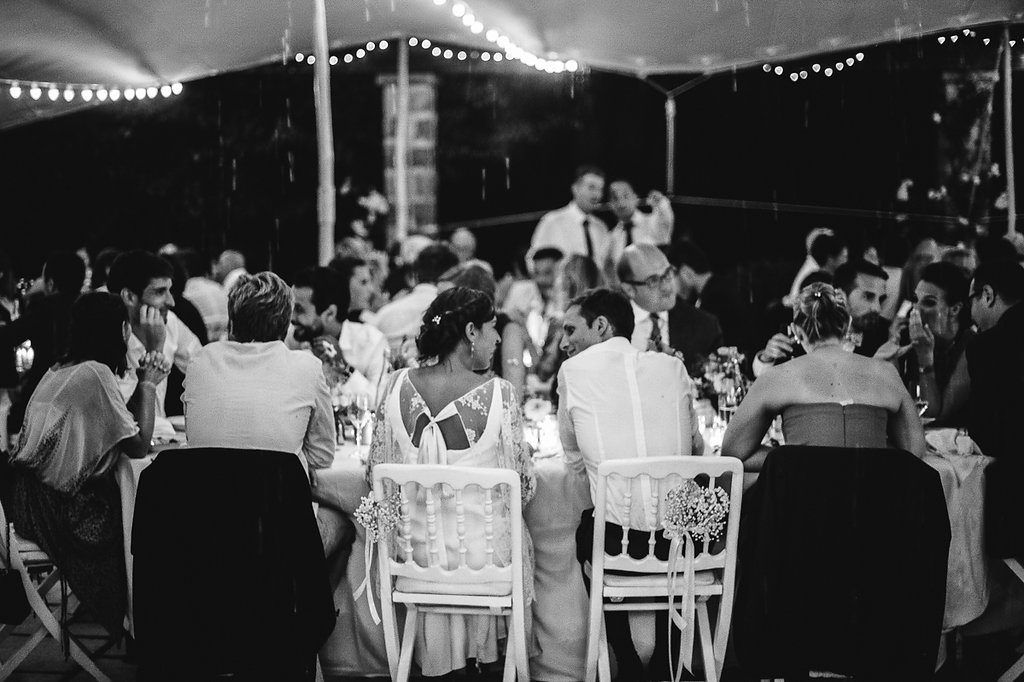 Black and white aerial view of wedding reception dinner under a marquee tent.