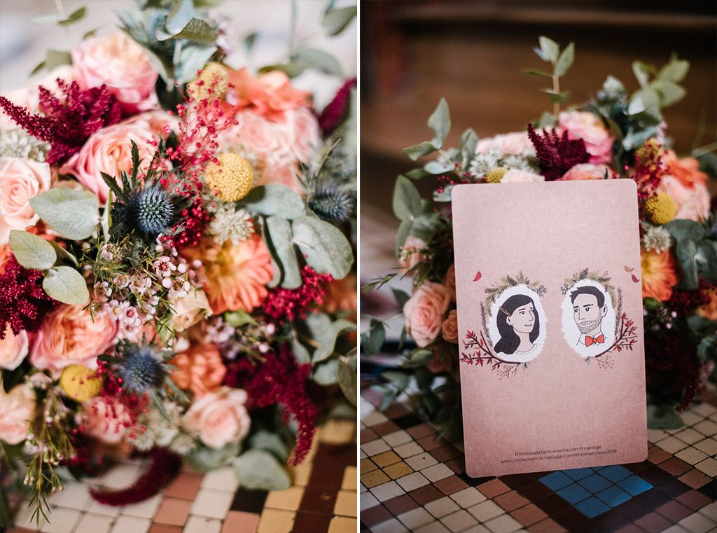 Vibrant bridal bouquet with burgundy, peach, and blue flowers beside a illustrated wedding program.
