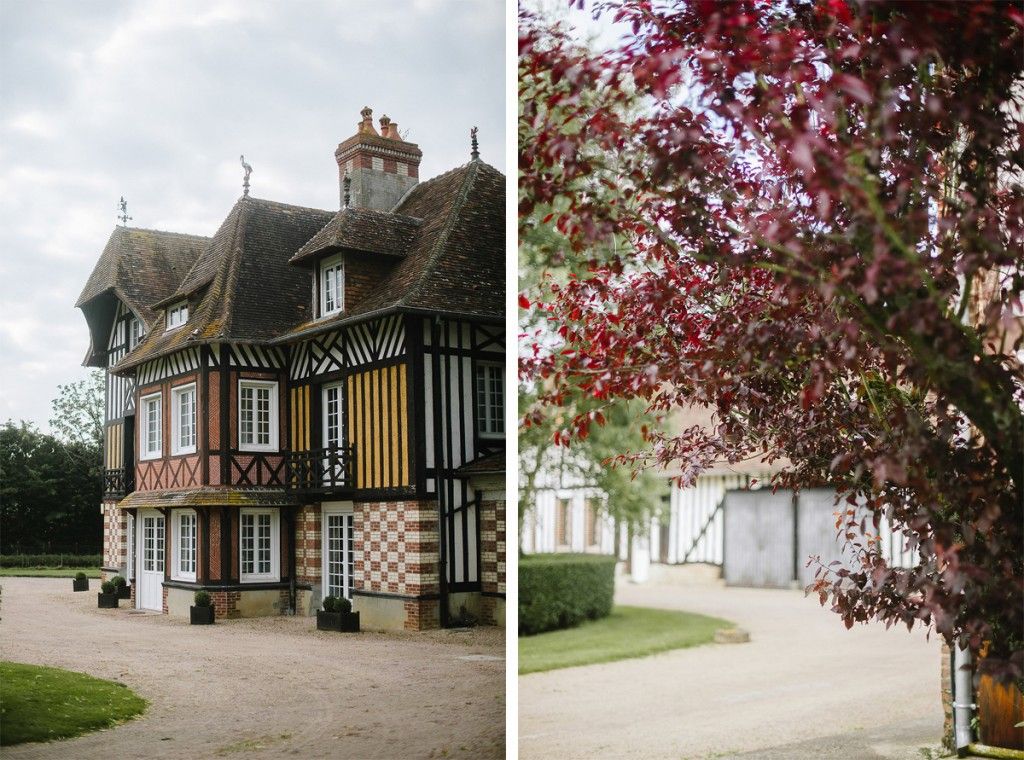 A charming Norman-style Tudor manor house with colorful timber framing surrounded by lush greenery in France.
