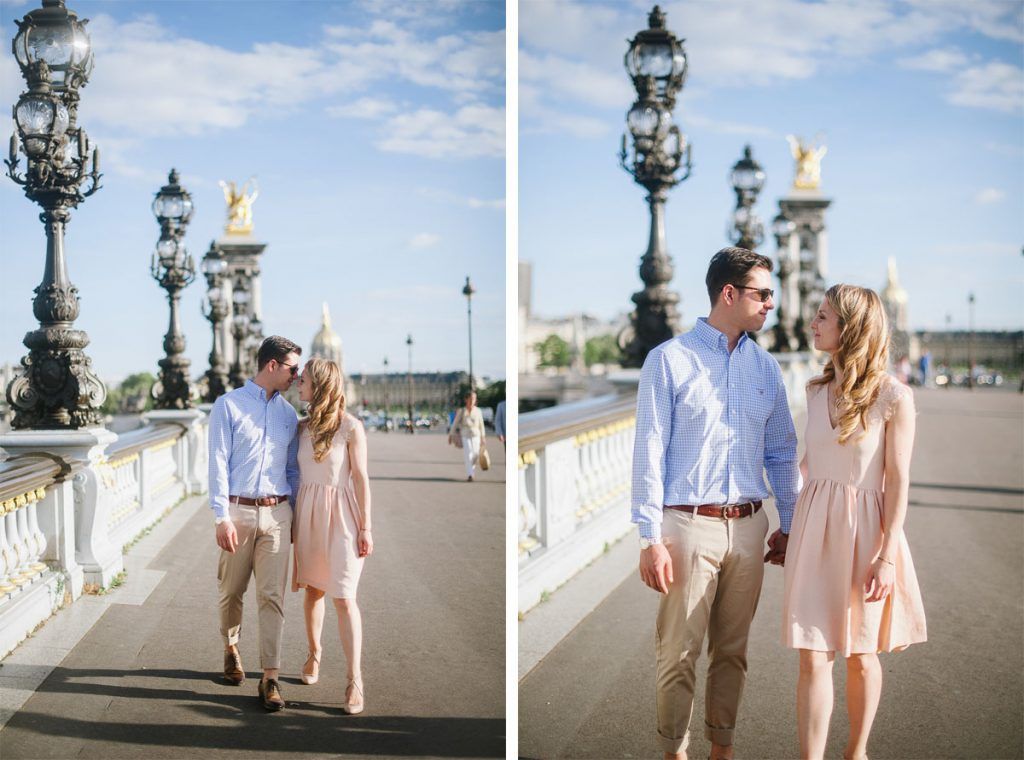 Couple walking hand in hand on Pont Alexandre III bridge in Paris on a sunny day.