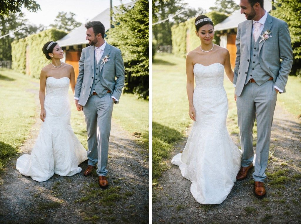 Wedding couple holding hands and walking together on a gravel path surrounded by greenery.