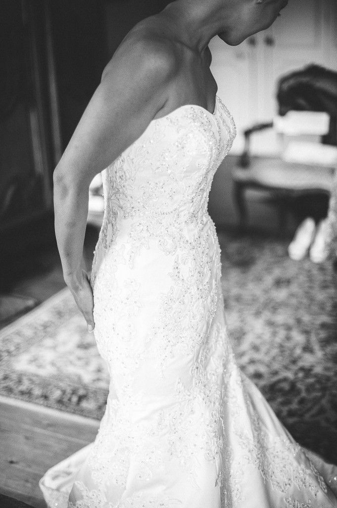 Close-up of bride in strapless beaded lace mermaid wedding gown in black and white.