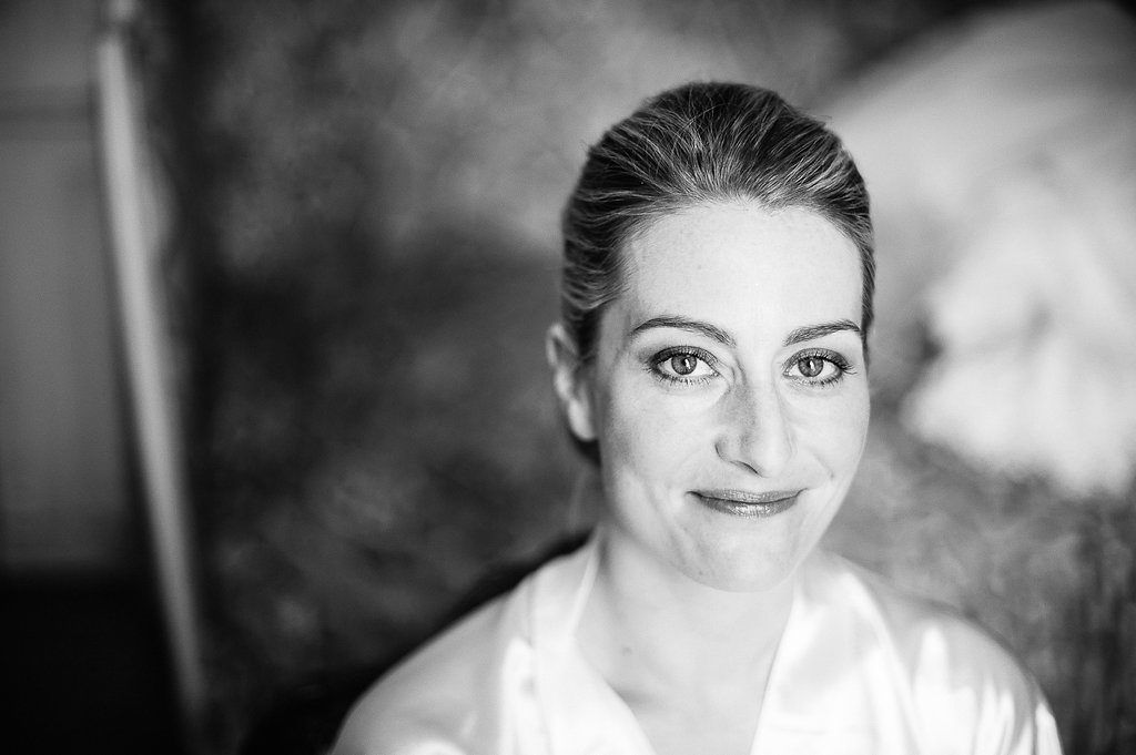 Black and white portrait of a bride in a white robe with elegant updo hairstyle.