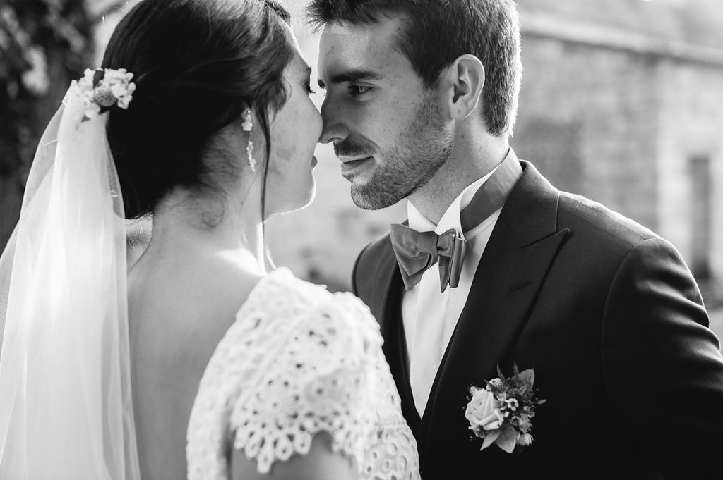 Close-up black and white portrait of bride and groom sharing a tender moment on wedding day.