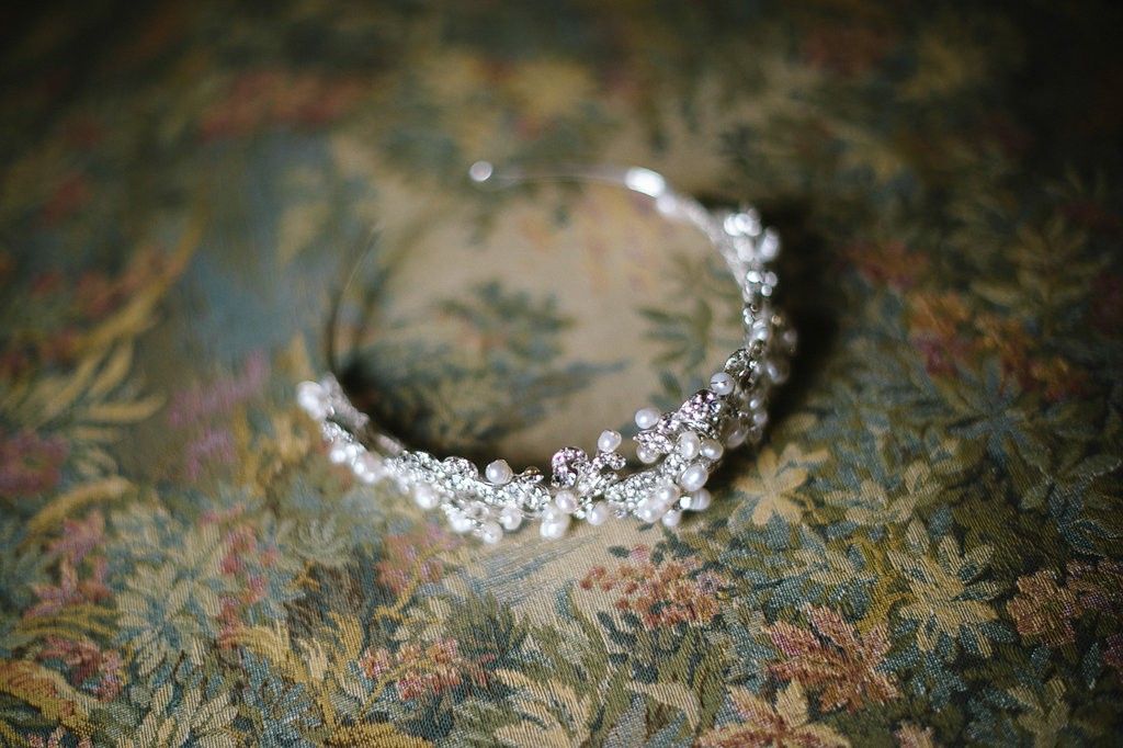 Sparkling crystal and rhinestone bridal tiara on a vintage floral fabric background.