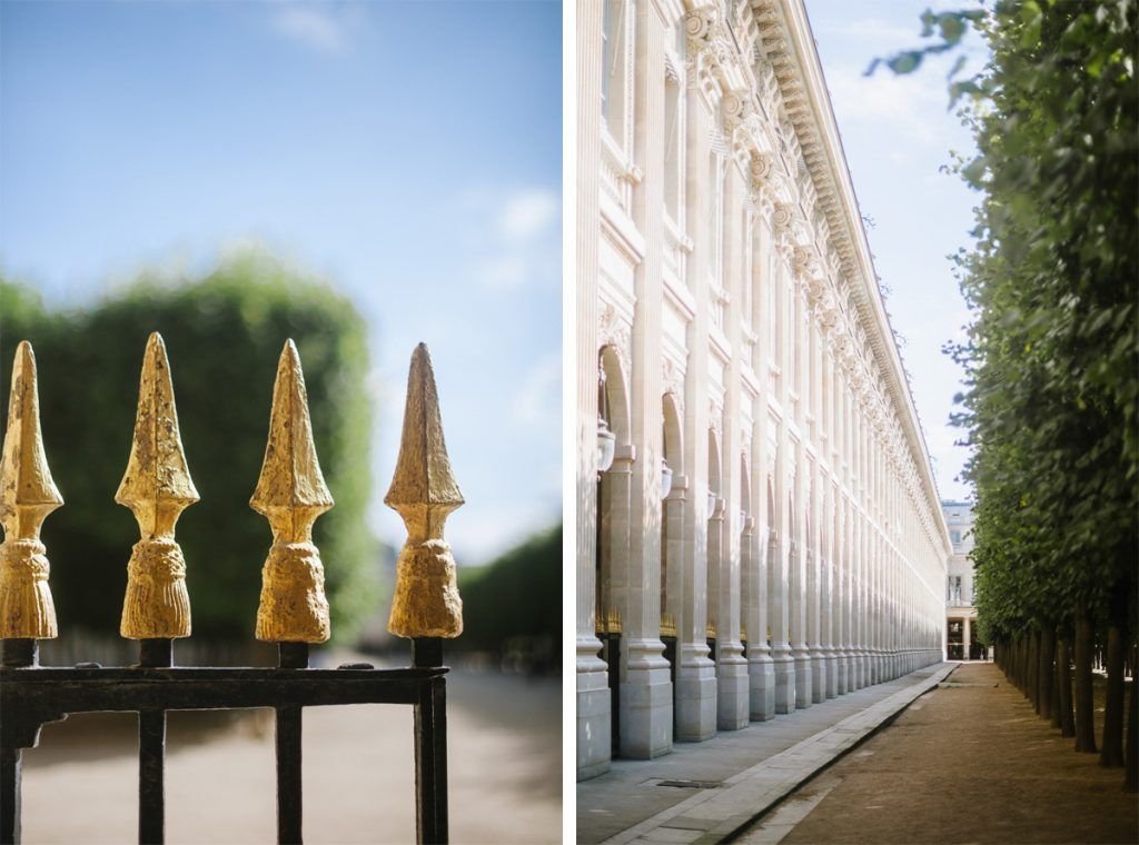 Golden iron fence spikes and white columned building exterior in classic Parisian architectural setting.
