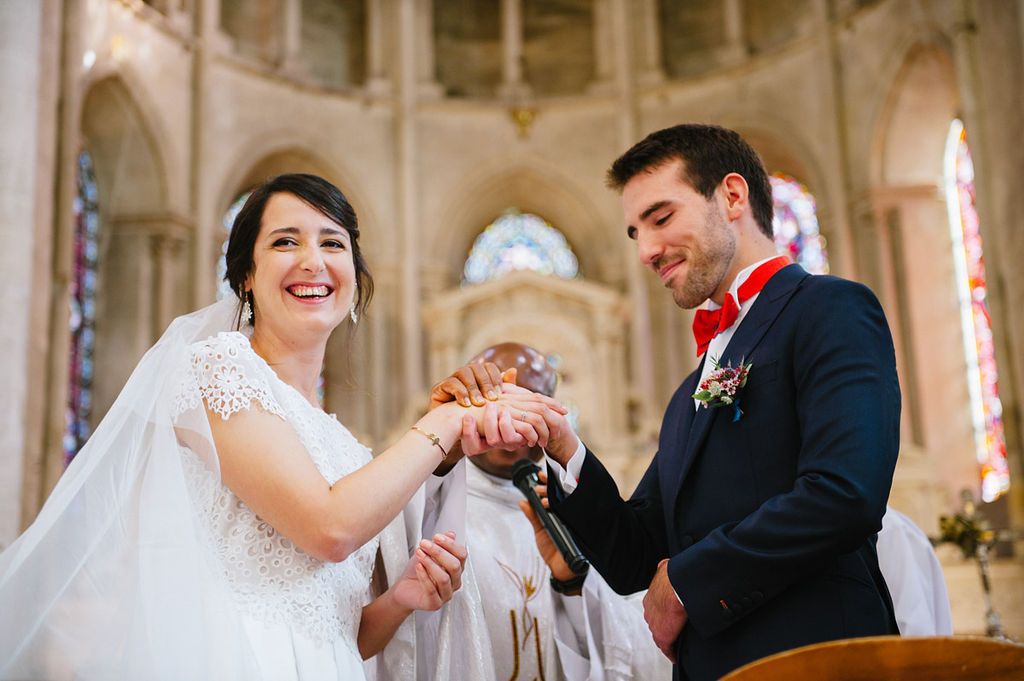 Bride and groom share a joyful moment exchanging wedding rings during their church ceremony.