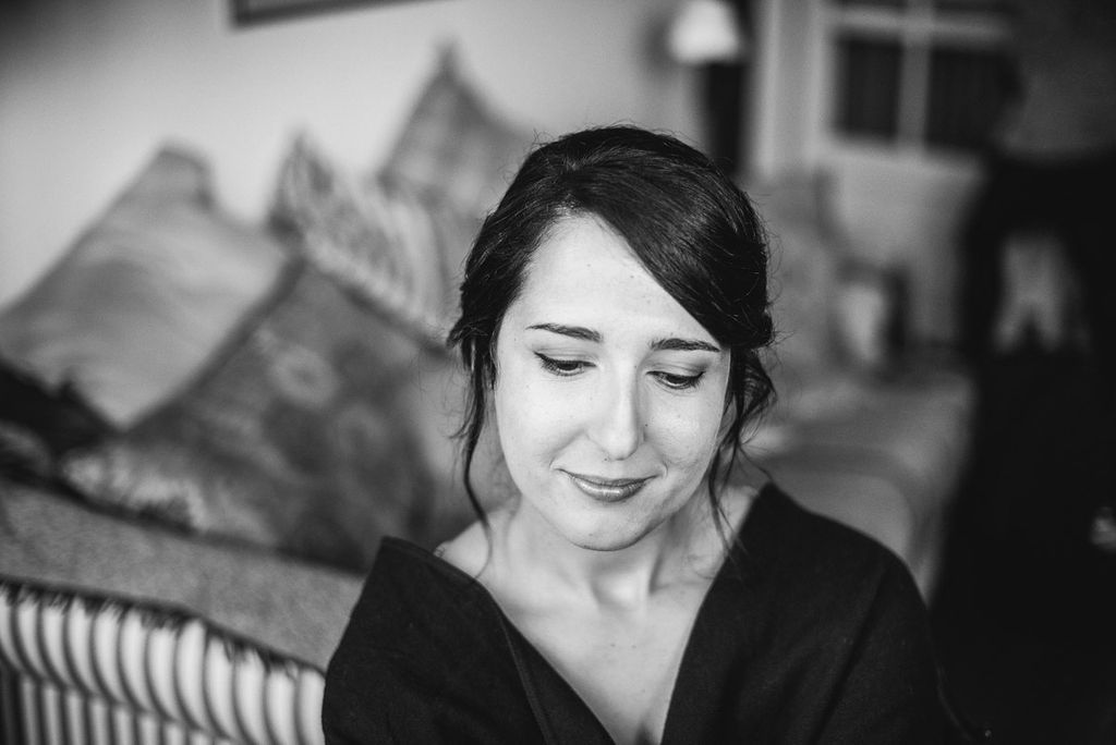 Black and white portrait of beautiful dark-haired bride during wedding morning preparation.