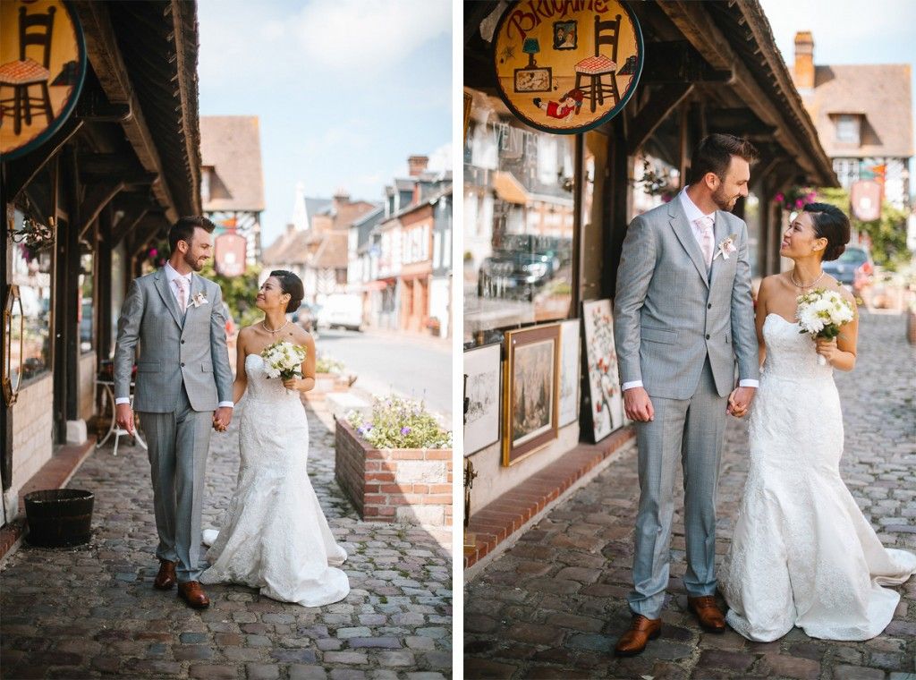 Wedding couple holds hands and gazes at each other on a charming European cobblestone street.