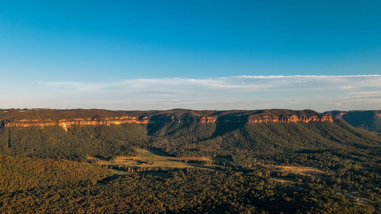 Panoramic view of rugged mountain cliffs and the Megalong valley stretching across below.