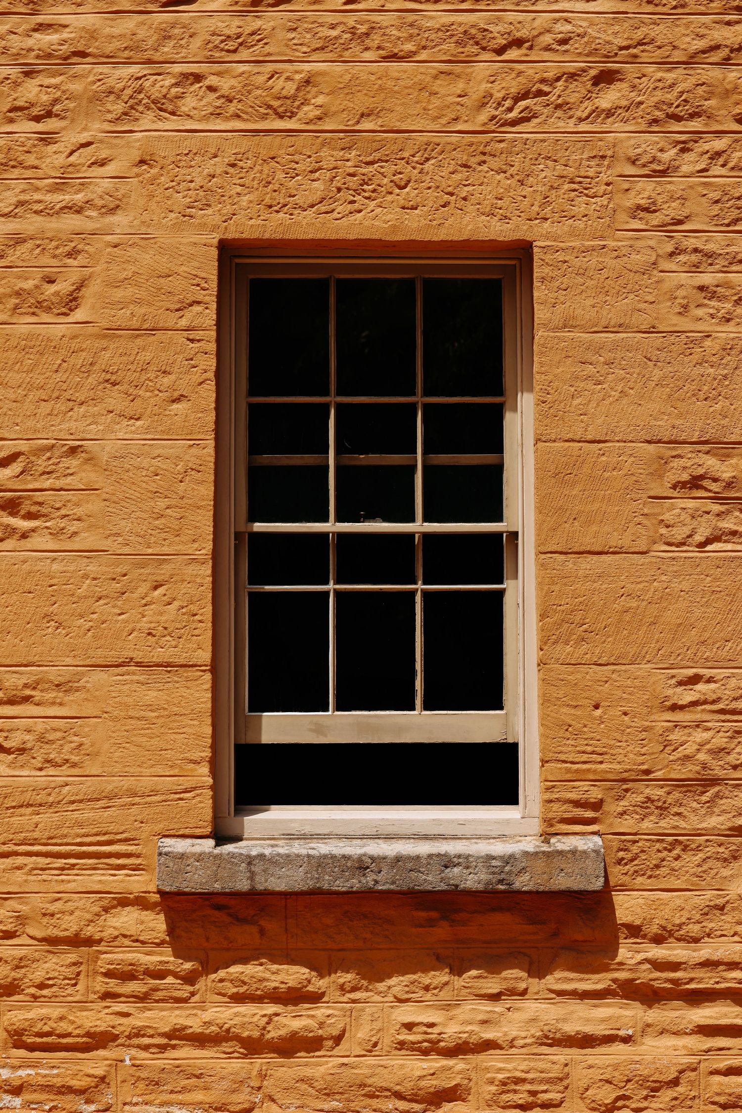 Historic sandstone building wall with symmetrical window.