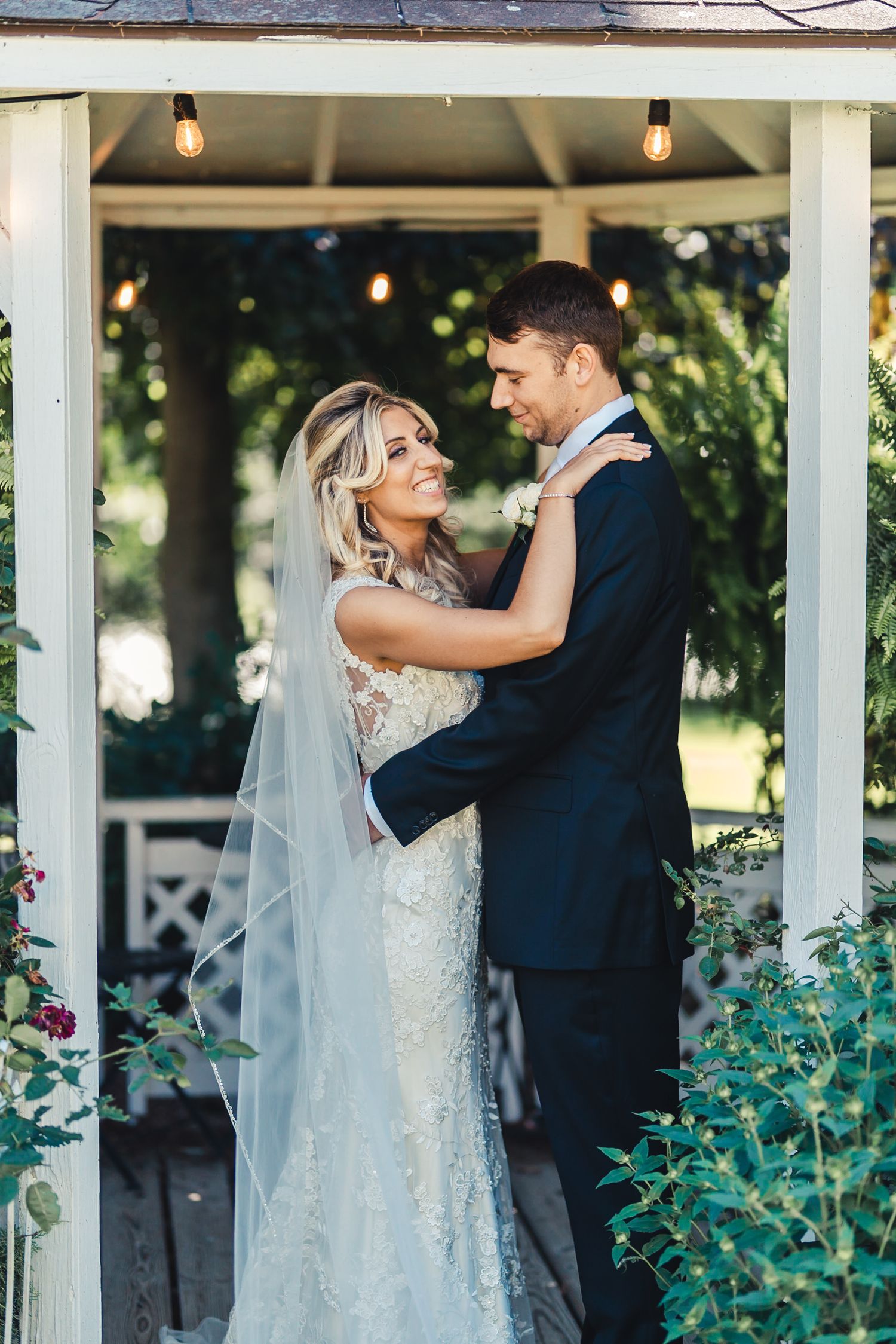 Bride and groom embracing under gazebo at Palm Beach Gardens wedding