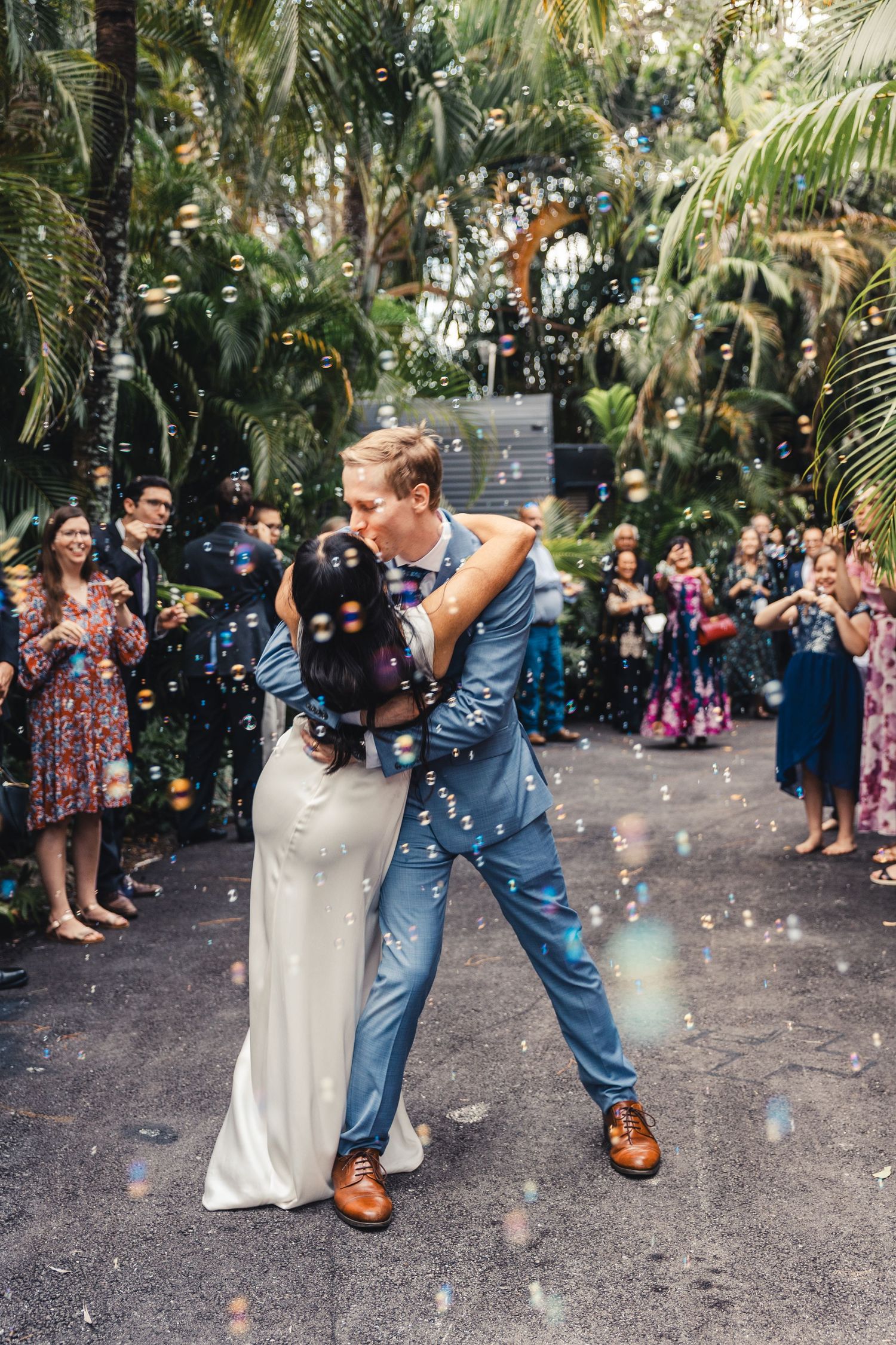 Bride and groom kissing during wedding exit celebration in Palm Beach Gardens
