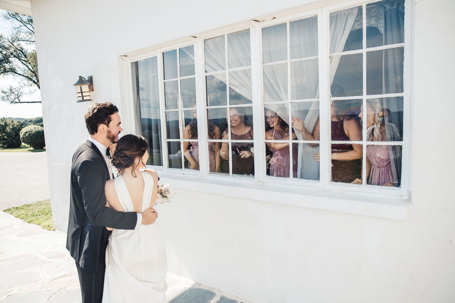 Bride and groom looking through windows during wedding day moment in Palm Beach Gardens