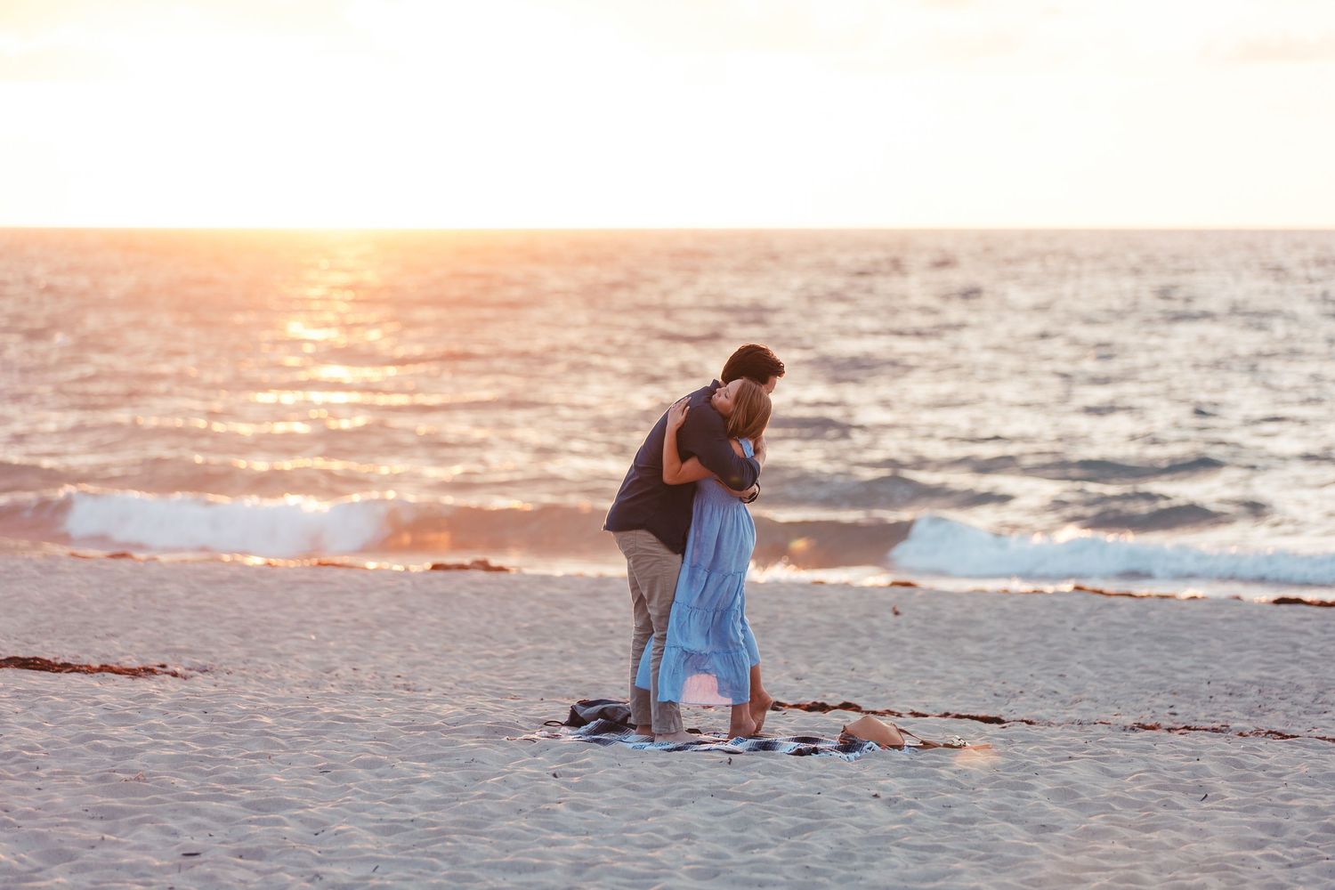 Couple embracing during beach engagement session in West Palm Beach