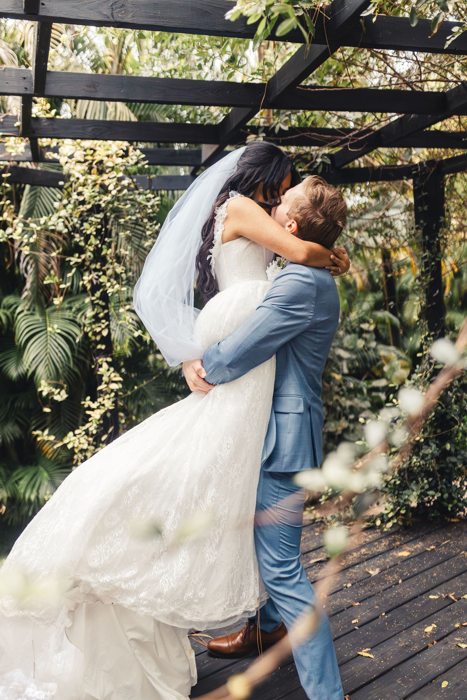 Bride and groom kissing during outdoor wedding portrait in Palm Beach Gardens