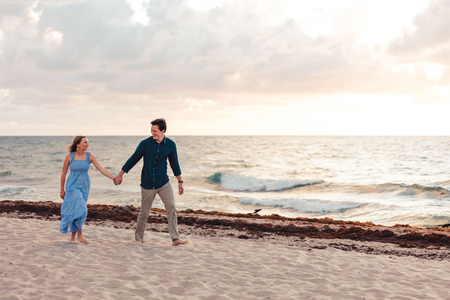 Couple holding hands during beach engagement session in Palm Beach Gardens