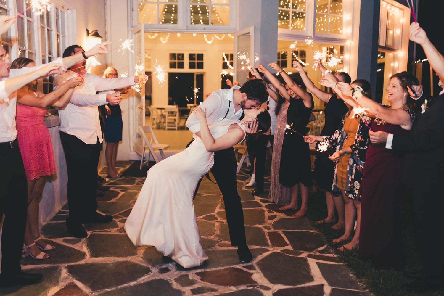 Bride and groom kissing during wedding reception exit in Palm Beach Gardens